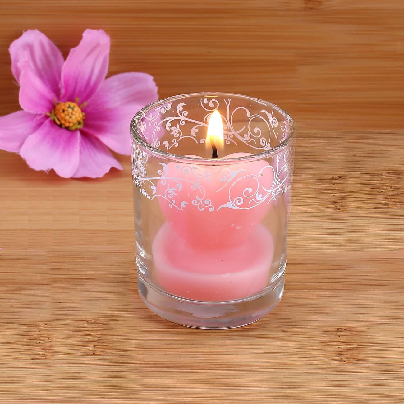 Kleine Herzförmige rosa Kerze im Glas –