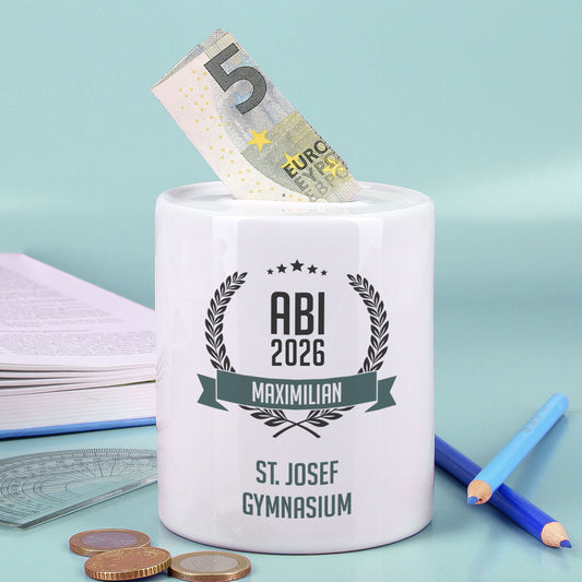 Persönliche Spardose als Geldgeschenk zum Abitur mit Geldschein vor grünem Hintergrund