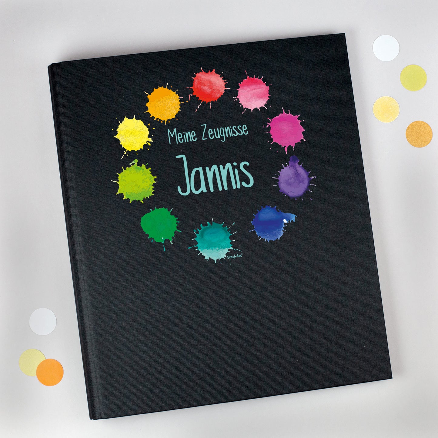 Zeugnismappe aus Leinen in Schwarz mit buntem Farbkleckse-Motiv und Name Jannis bedruckt