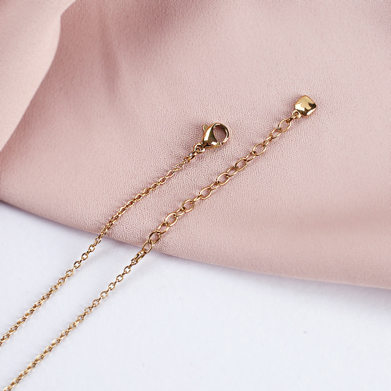 Nahaufnahme des Verschlusses der goldenen Leonardo Herzkette zur Geburt mit Name und Datum des Babys graviert