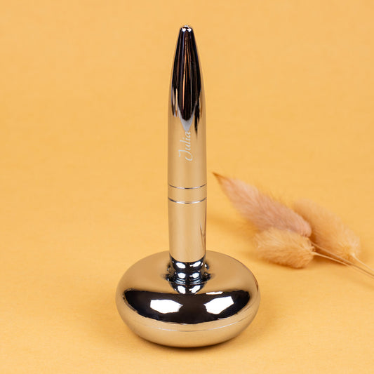 Magischer Kugelschreiber mit Namensgravur stehend in Ständer auf gelbem Hintergrund dekoriert mit Halm