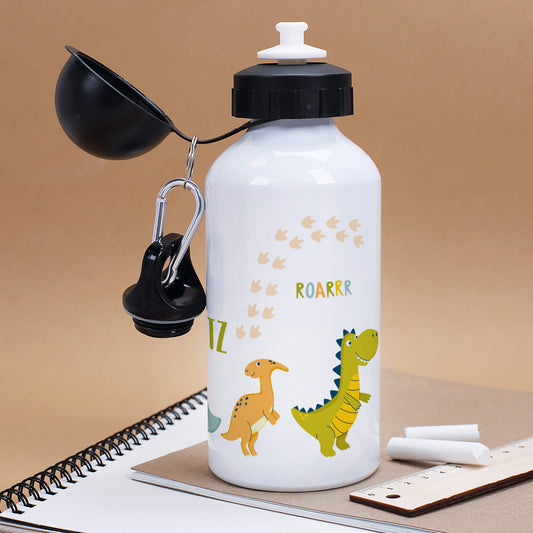 Kindgerechte Trinkflasche mit bunten Dinos und Name – geöffnet mit Trinkverschluss, auf Notizblock