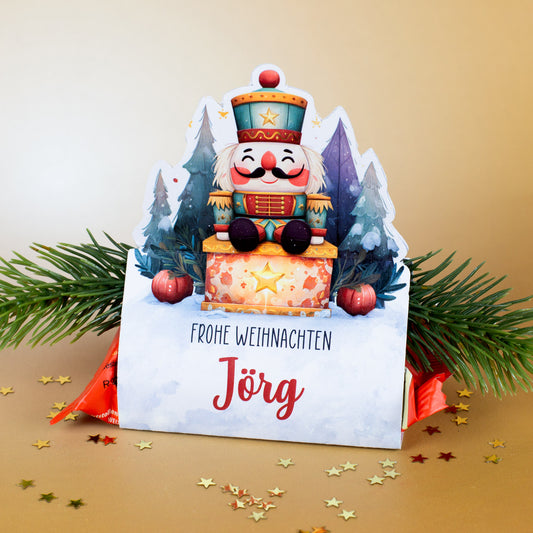 Mini-Stollen in personalisierter Nussknacker-Verpackung „Jörg“ mit festlicher Golddekoration und Tannengrün