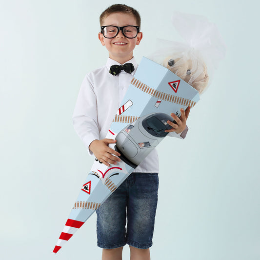 Junge in Hemd hält Zuckertüte mit ICE-Motiv