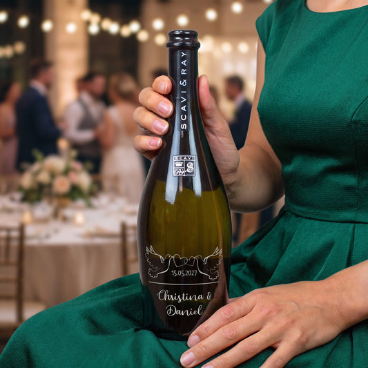 Person hält personalisierte Scavi & Ray Prosecco-Flasche zur Hochzeit mit Namen Christina & Daniel vor festlicher Kulisse