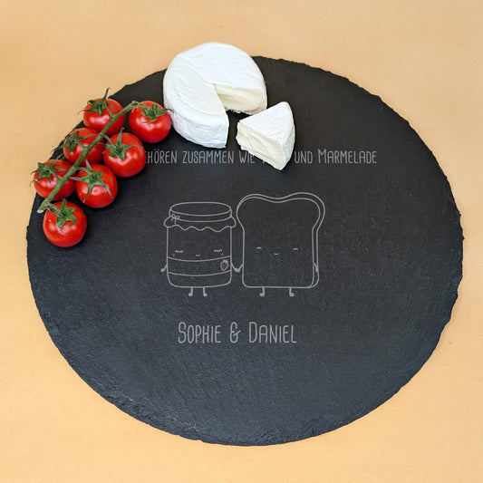 Runde Schieferplatte mit Gravur „Wir gehören zusammen wie Toast und Marmelade“ und zwei Namen, serviert mit Camembert und Tomaten