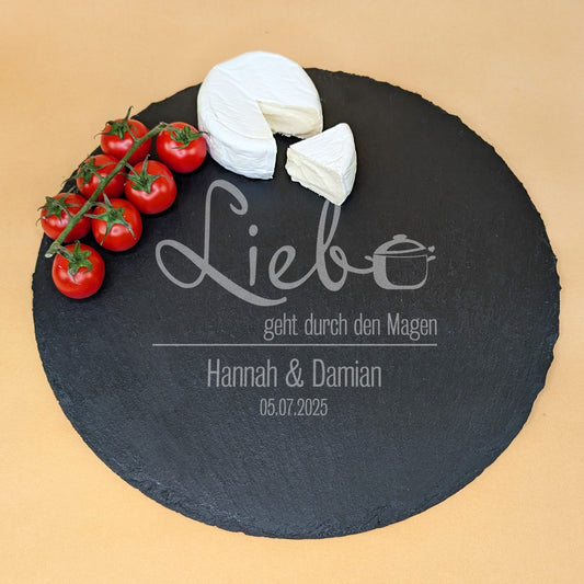 Runde Schieferplatte mit Gravur „Liebe geht durch den Magen“, zwei Namen und Datum, serviert mit Camembert und Tomaten