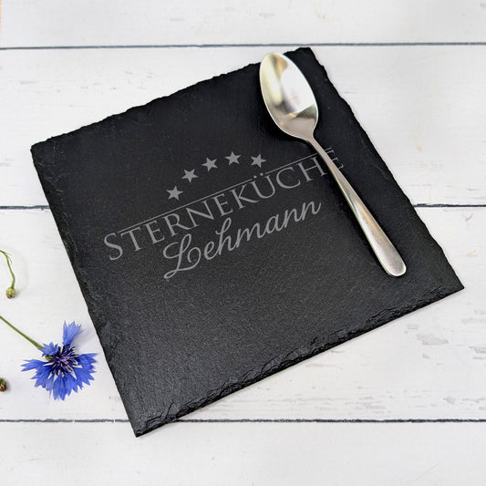 Gravierte Platte auf Tisch mit Löffel und Blume