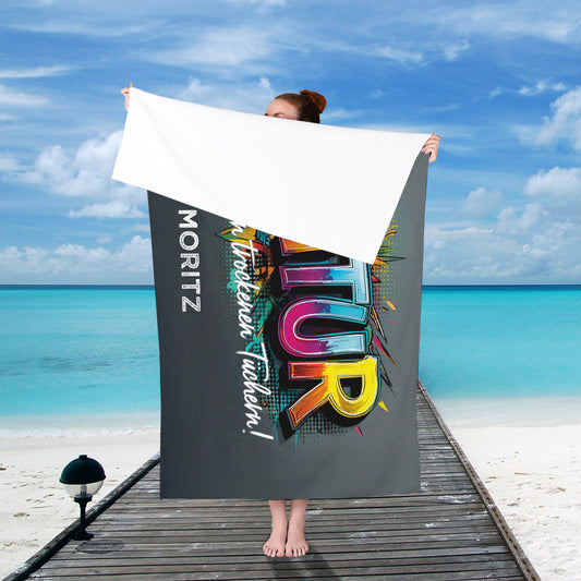 Person hält das personalisierte Abitur-Handtuch im Hochformat vor sich – Graffiti-Schriftzug „ABITUR“ und Wunschtext sind sichtbar.