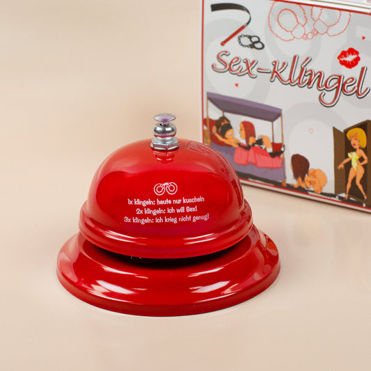 Sex-Klingel in Rot mit Aufdruck, Geschenkidee für Paare – neben Verpackung gezeigt