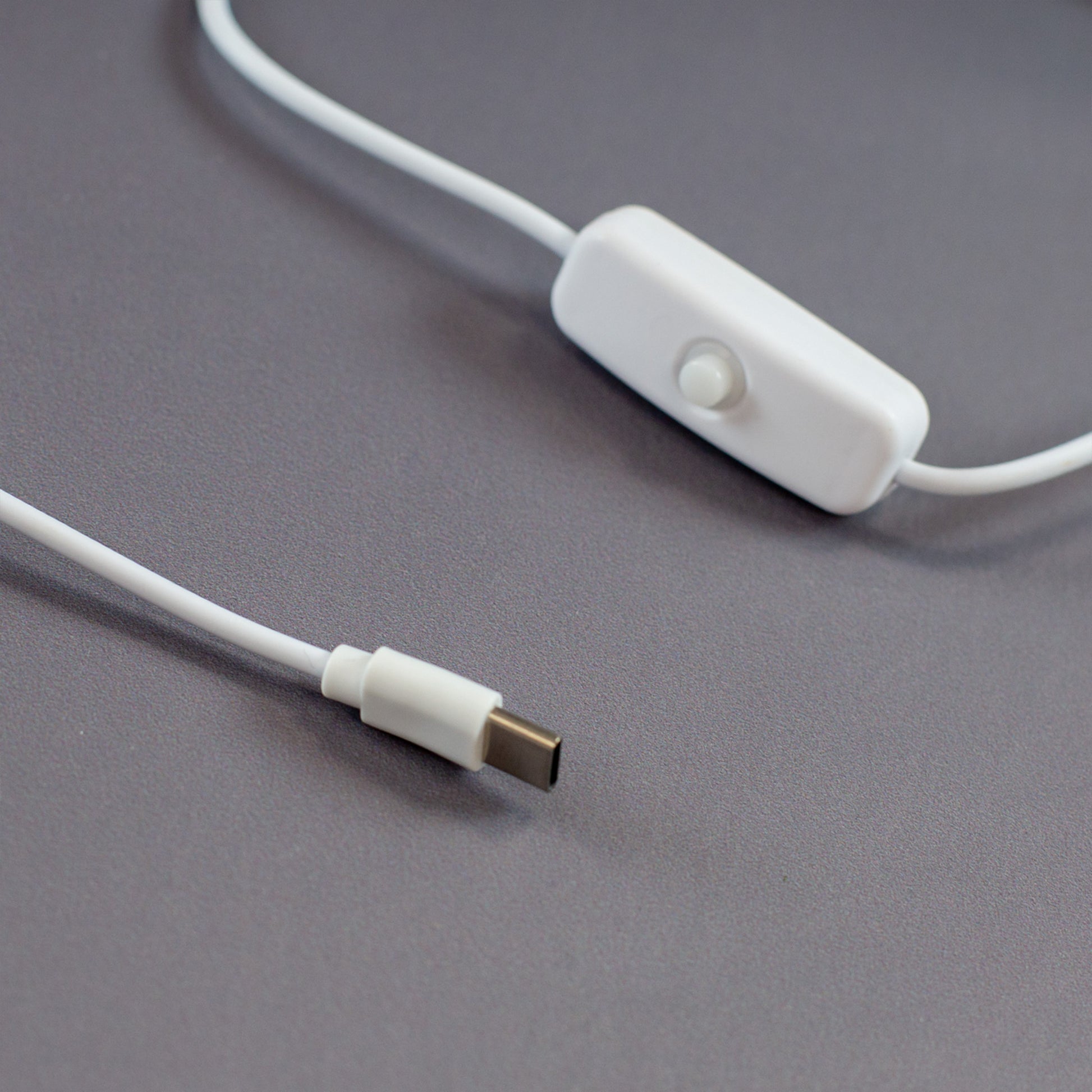 USB-C Kabel der LED Acryl-Lampe mit weißem An/Aus-Schalter und Stecker in Nahaufnahme auf grauem Hintergrund