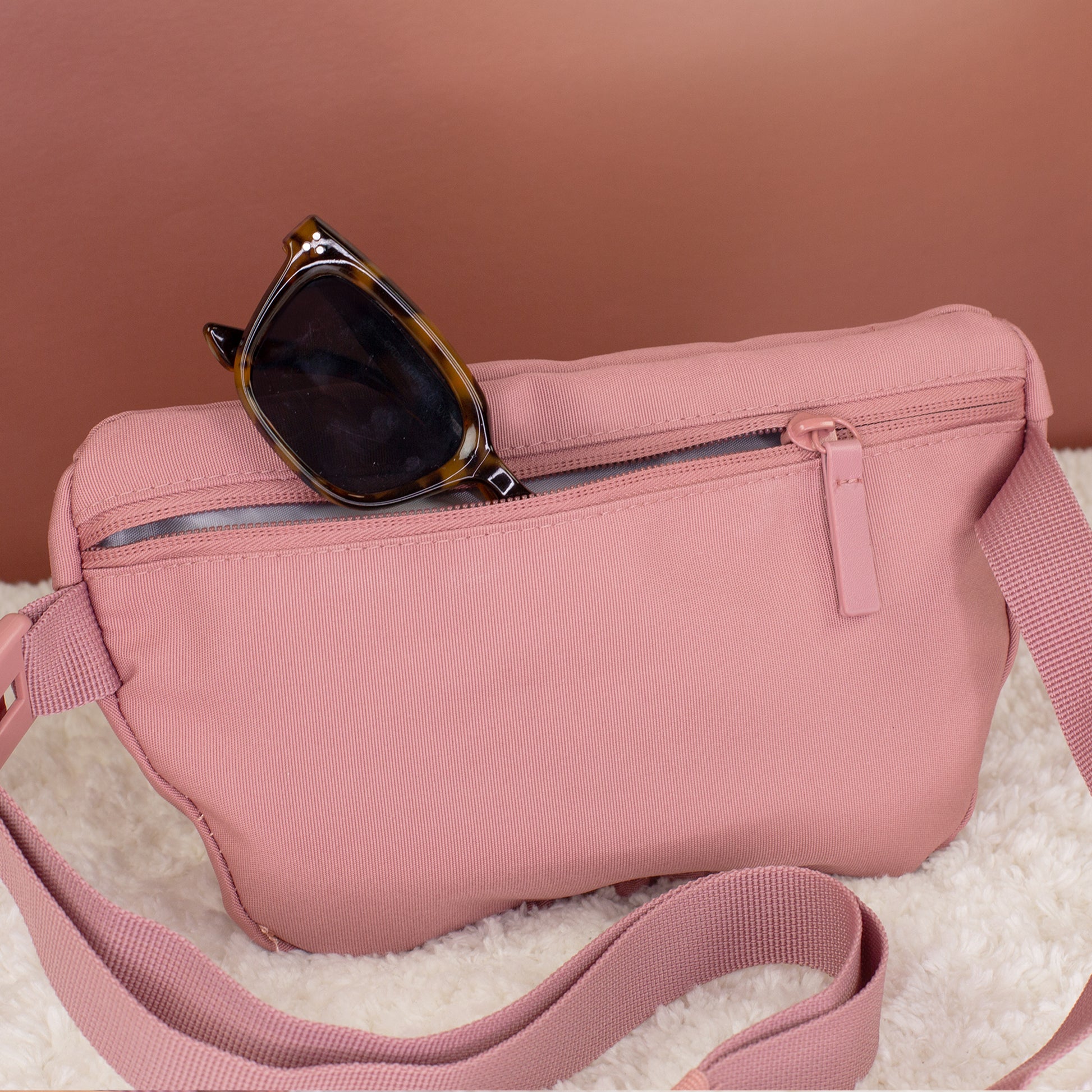 Rückseite der rosa Dog Mom Bauchtasche mit Reißverschlussfach und eingesteckter Sonnenbrille