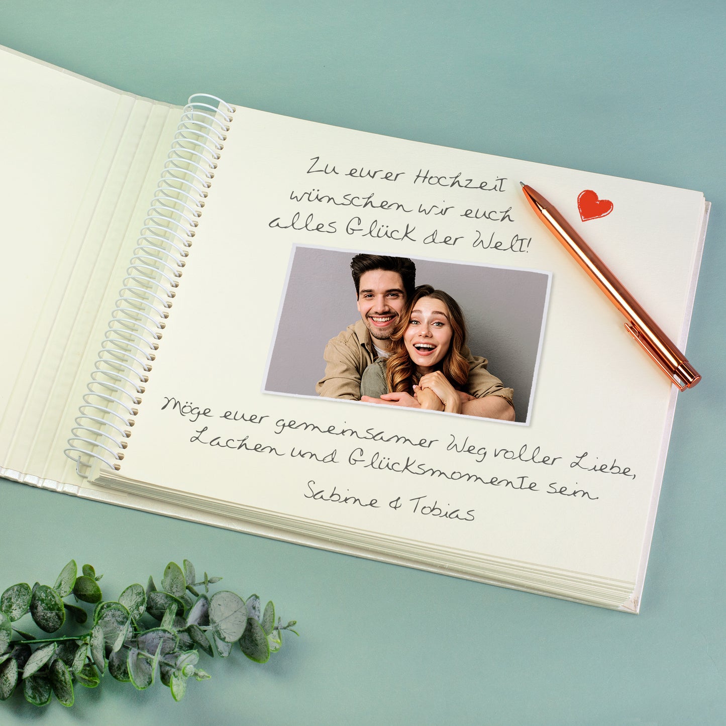 Innenseite des Gästebuchs mit Spiralbindung, eingeklebtem Foto und handgeschriebenem Hochzeitsgruß von Gästen.
