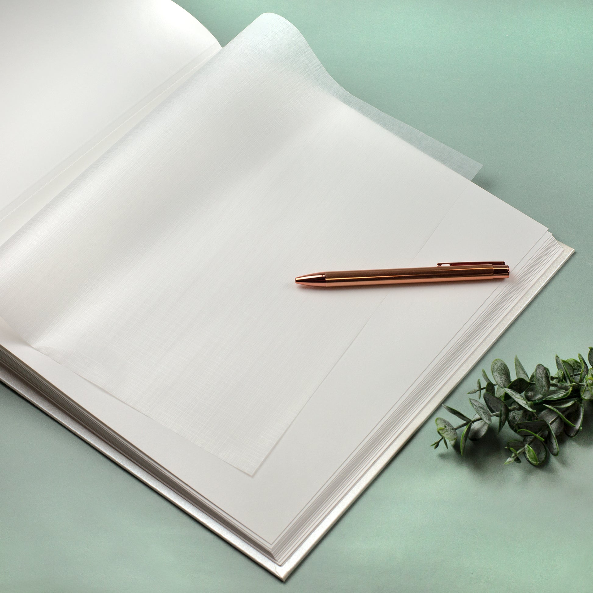 Leere Albumseite mit Pergaminpapier zum Schutz der Fotos im Hochzeitsalbum