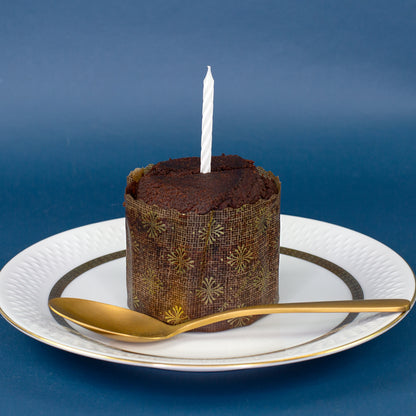 Schokoladen-Brownie aus dem Dosenkuchen mit Kerze auf einem Teller als kleine Geburtstagsüberraschung