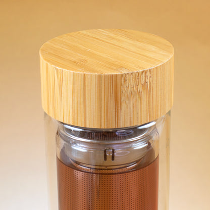 Nahaufnahme des Bambusdeckels auf der doppelwandigen Glasflasche mit Edelstahl-Teesieb
