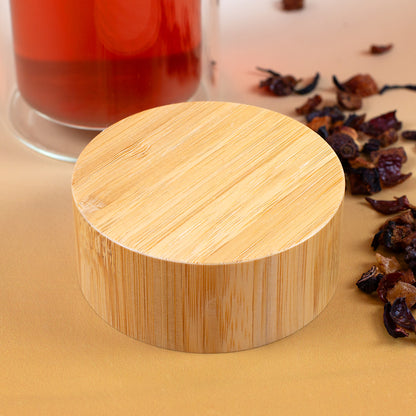 Außenseite des runden Bambusdeckels mit natürlicher Holzmaserung neben losem Früchtetee