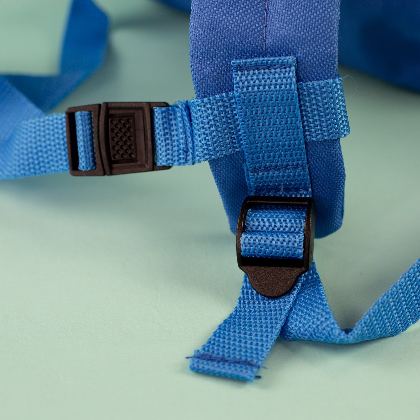 Nahaufnahme der verstellbaren Trageriemen und Steckverschlüsse am blauen Kindergartenrucksack