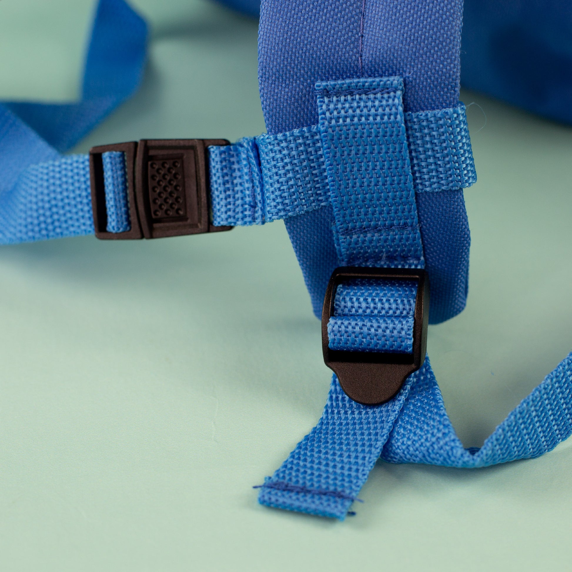 Nahaufnahme der verstellbaren Trageriemen und Steckverschlüsse am blauen Kindergartenrucksack
