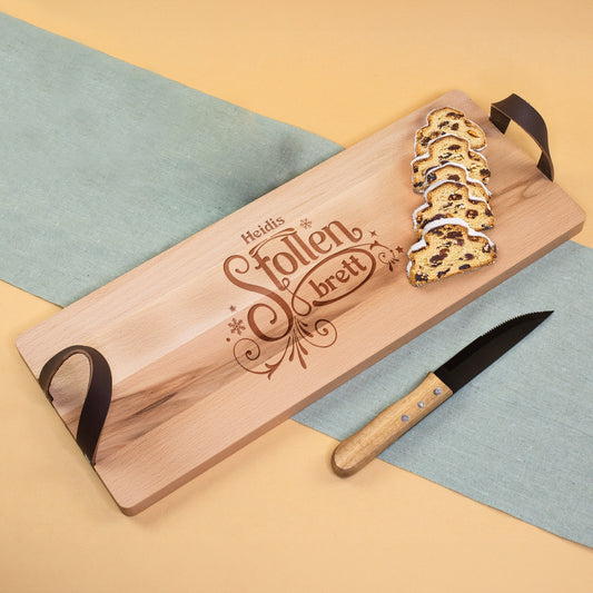 Stollenbrett mit Namensgravur und Ledergriffen, serviert mit angeschnittenem Christstollen
