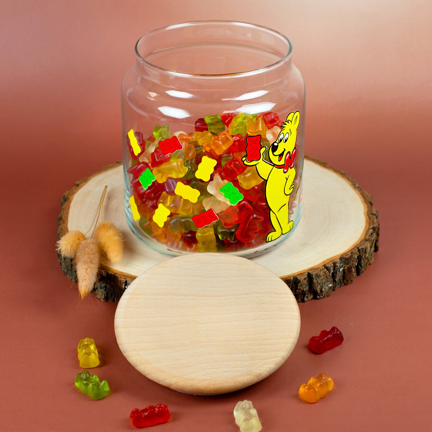 Gummibärchen Dose aus Glas mit HARIBO Goldbär Motiv und Holzdeckel auf Holzscheibe dekoriert