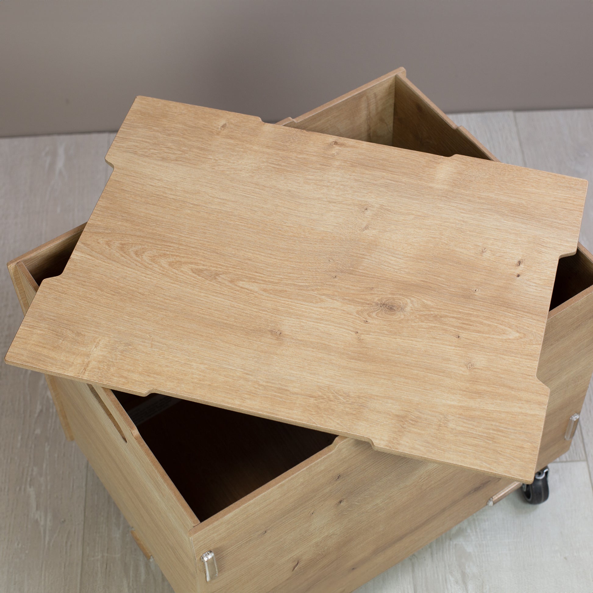 Detailaufnahme des passgenauen Holzdeckels der Rollkiste, robuste Oberfläche in natürlicher Holzoptik