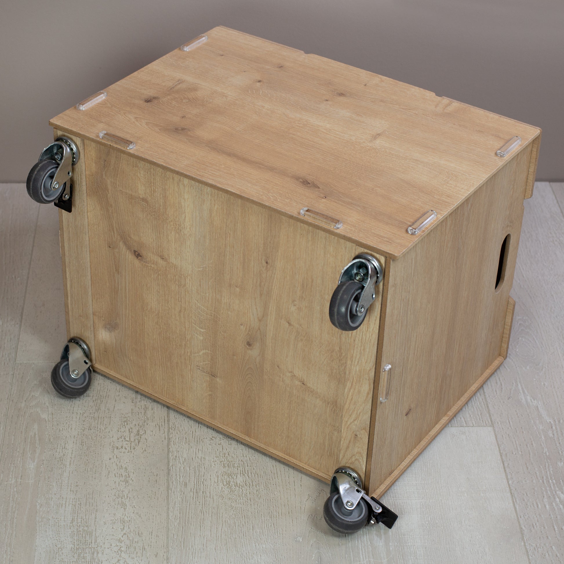 Ansicht von seitlich unten der Holz-Rollbox mit vier stabilen Rollen, zwei davon mit Feststellbremse, schlichte Darstellung ohne Personalisierung