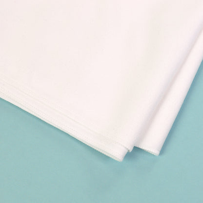 Detailaufnahme von Material und Naht eines weißen Sporthandtuchs auf türkisem Hintergrund