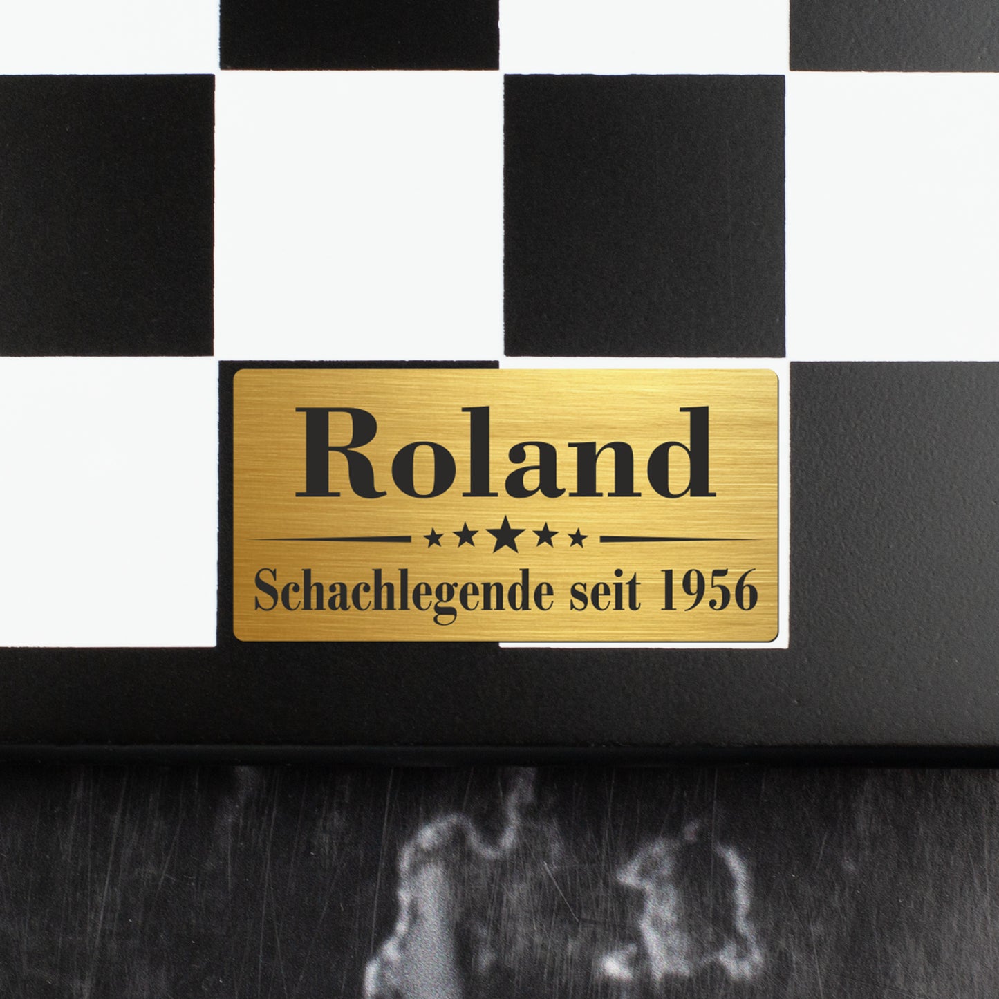 Nahaufnahme der goldfarbenen Metallplakette mit Gravur Roland Schachlegende seit 1956 auf dem Schachbrett