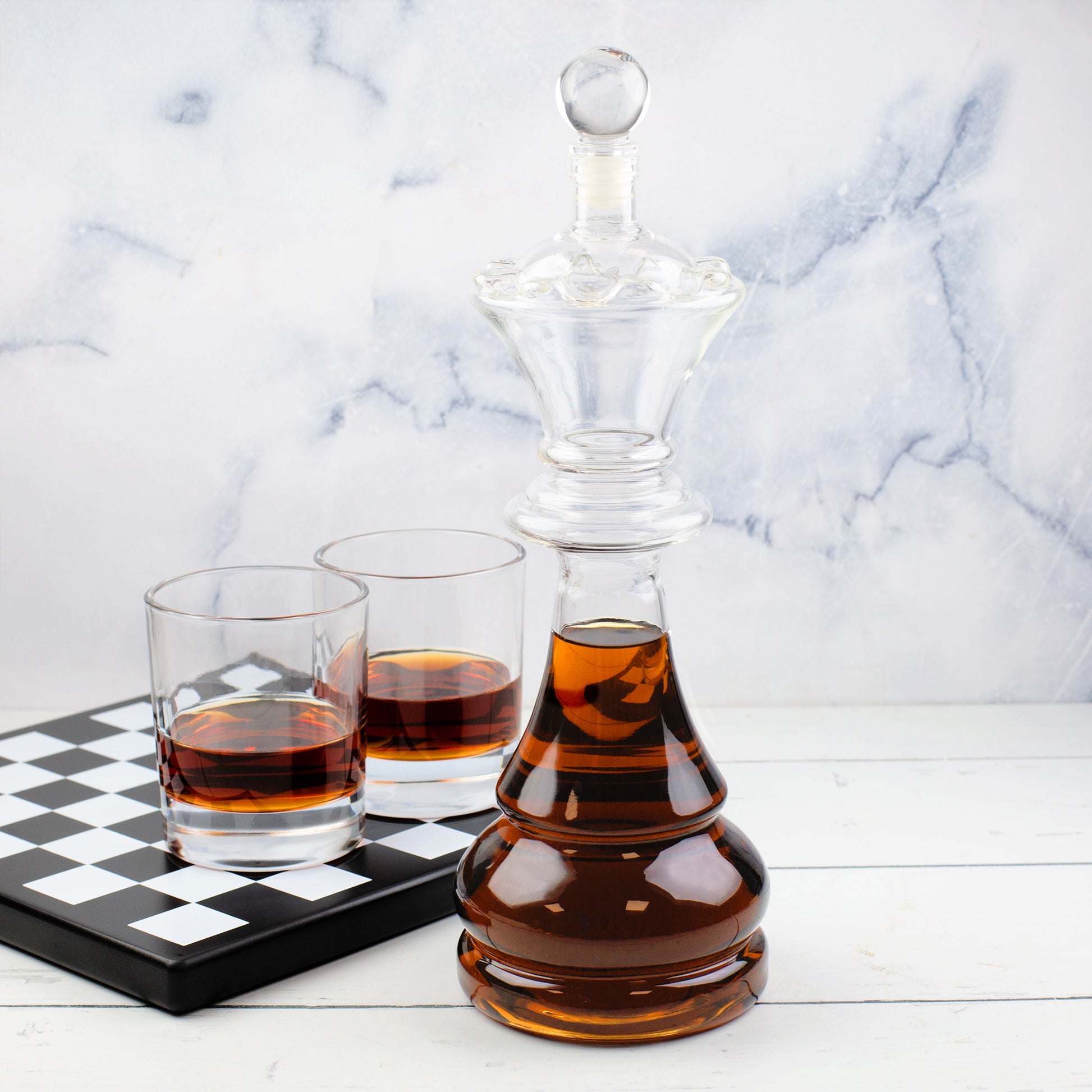 Dekanter Set mit Schachbrett-Sockel, König Karaffe und Whiskygläsern vor heller Marmoroptik