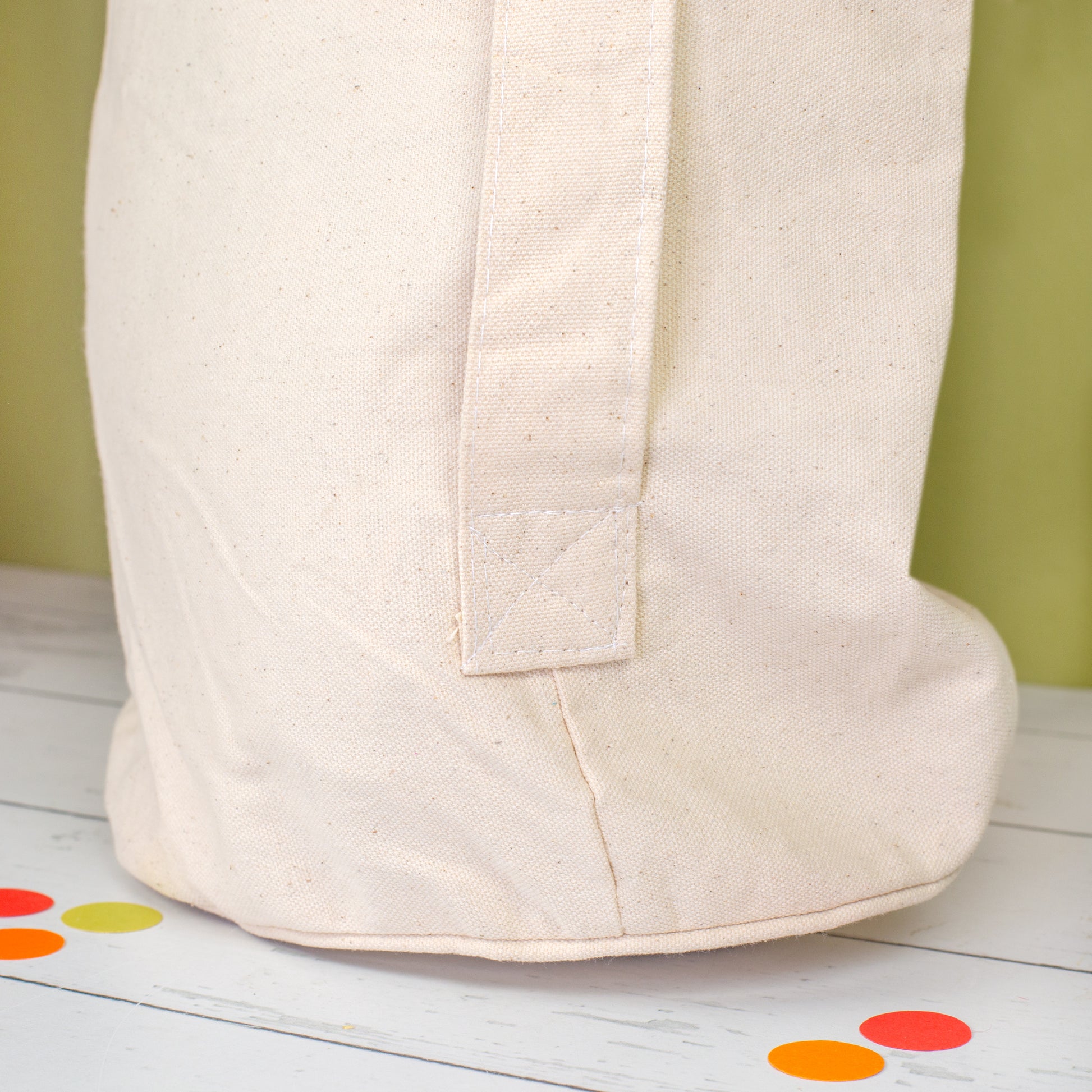 Detailaufnahme der unteren Seitennaht und Trageschlaufe des naturfarbenen Geschenkesacks in Seesack-Form für XXL Jenga