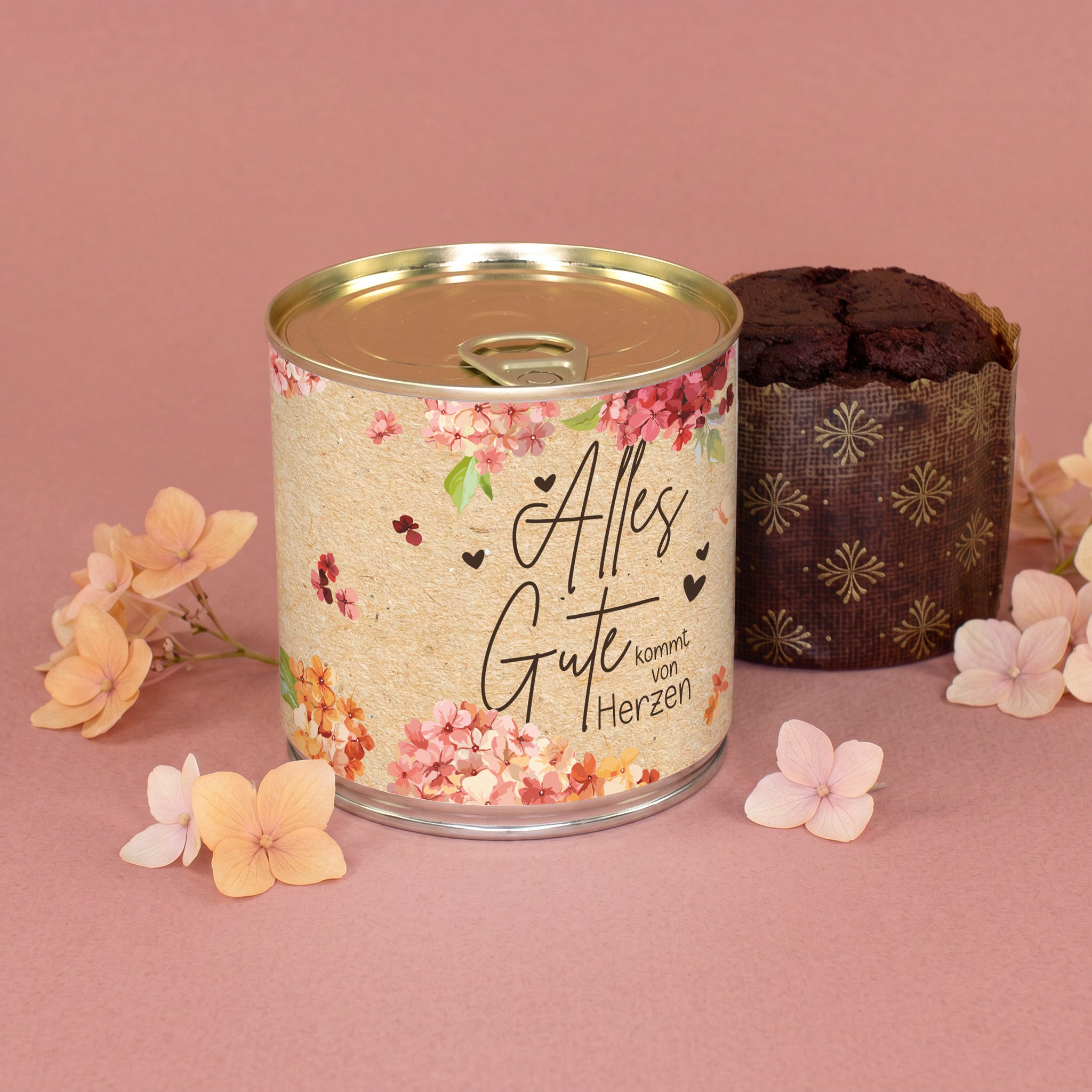 Brownie Kuchen in der Dose mit floralem Alles Gute Motiv und Blütendekoration auf rosa Hintergrund