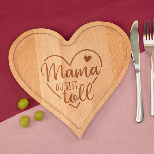 Herz Frühstücksbrettchen aus Holz mit Gravur Mama du bist toll auf rotem Hintergrund mit Besteck