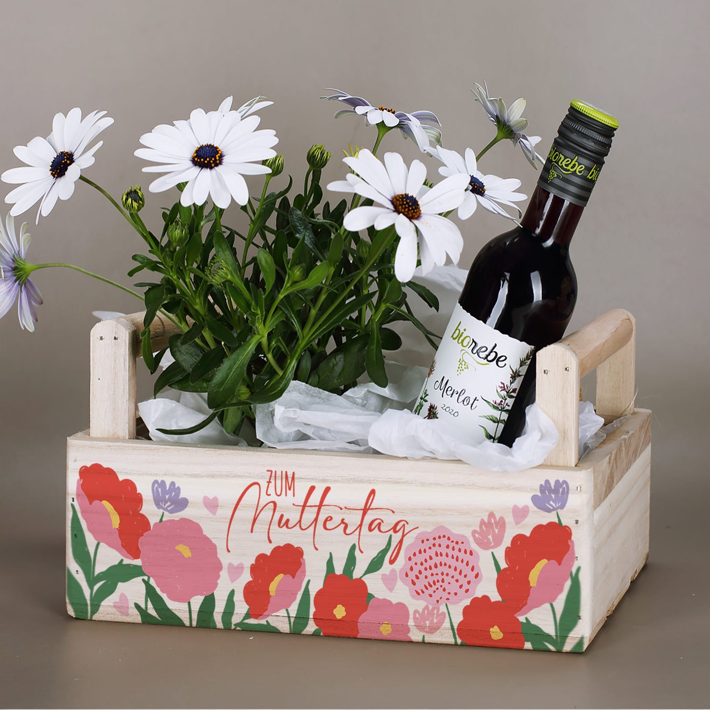 Pflanzkorb als Geschenkverpackung mit Blumen und Wein zum Muttertag