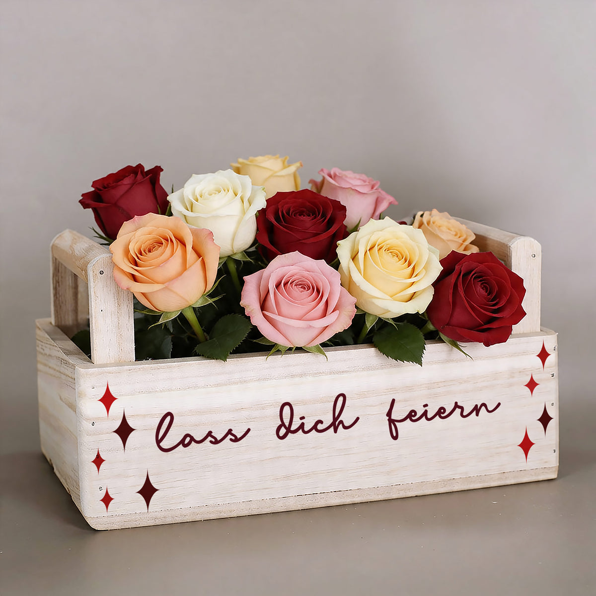 Holzkiste zum Geburtstag mit bunten Rosen und Schriftzug „Lass dich feiern“ auf der Vorderseite