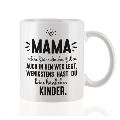 Freigestellte weiße Keramiktasse mit Aufdruck „Mama – wenigstens keine hässlichen Kinder“, Vorderansicht