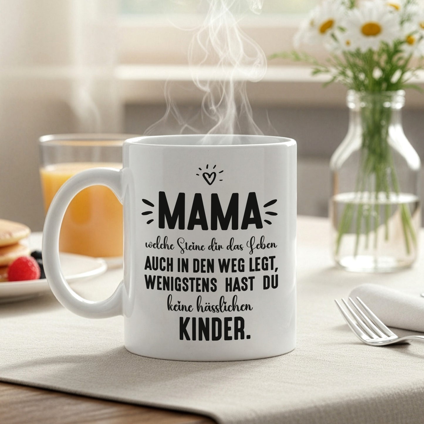 Weiße Kaffeetasse mit Mama-Spruch auf gedecktem Frühstückstisch mit Dampf und Tageslicht