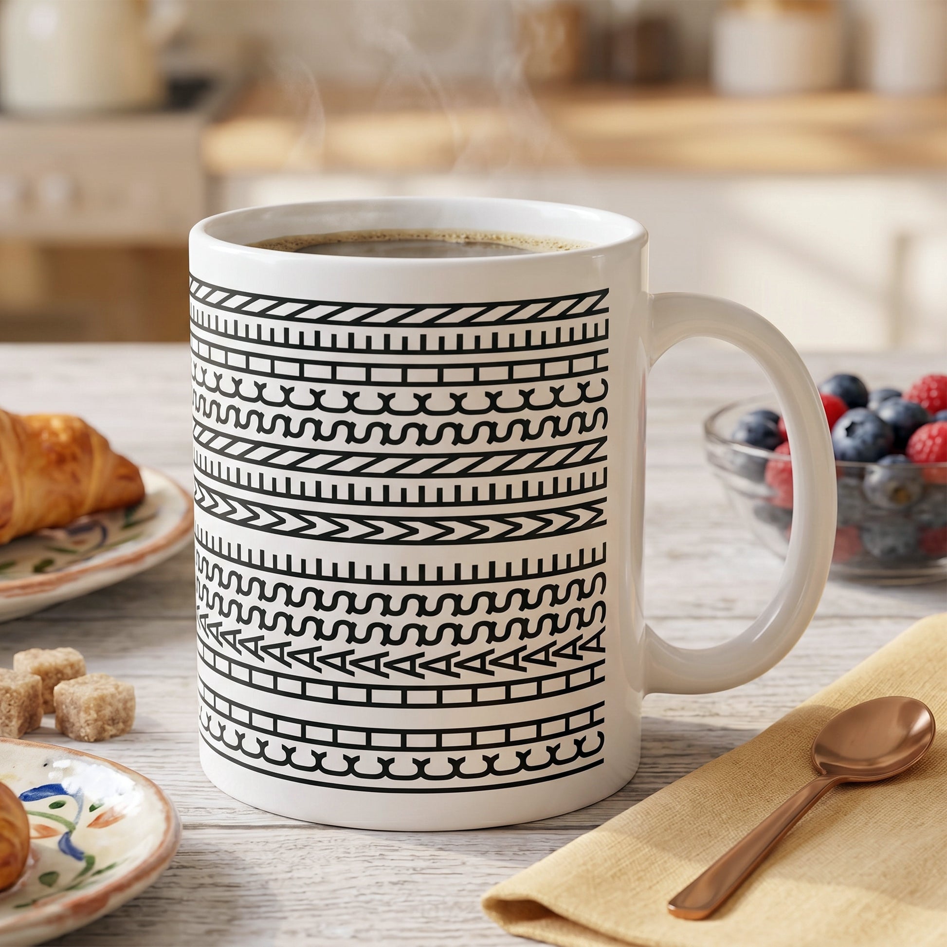 Lustige Tasse mit verstecktem Schriftzug auf Frühstückstisch neben Croissant und Beeren