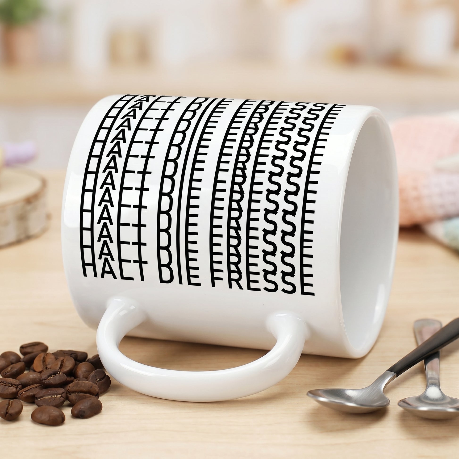 Liegende weiße Tasse mit sichtbarer versteckter Botschaft „Halt die Fresse“ im schwarzen Buchstabenmuster