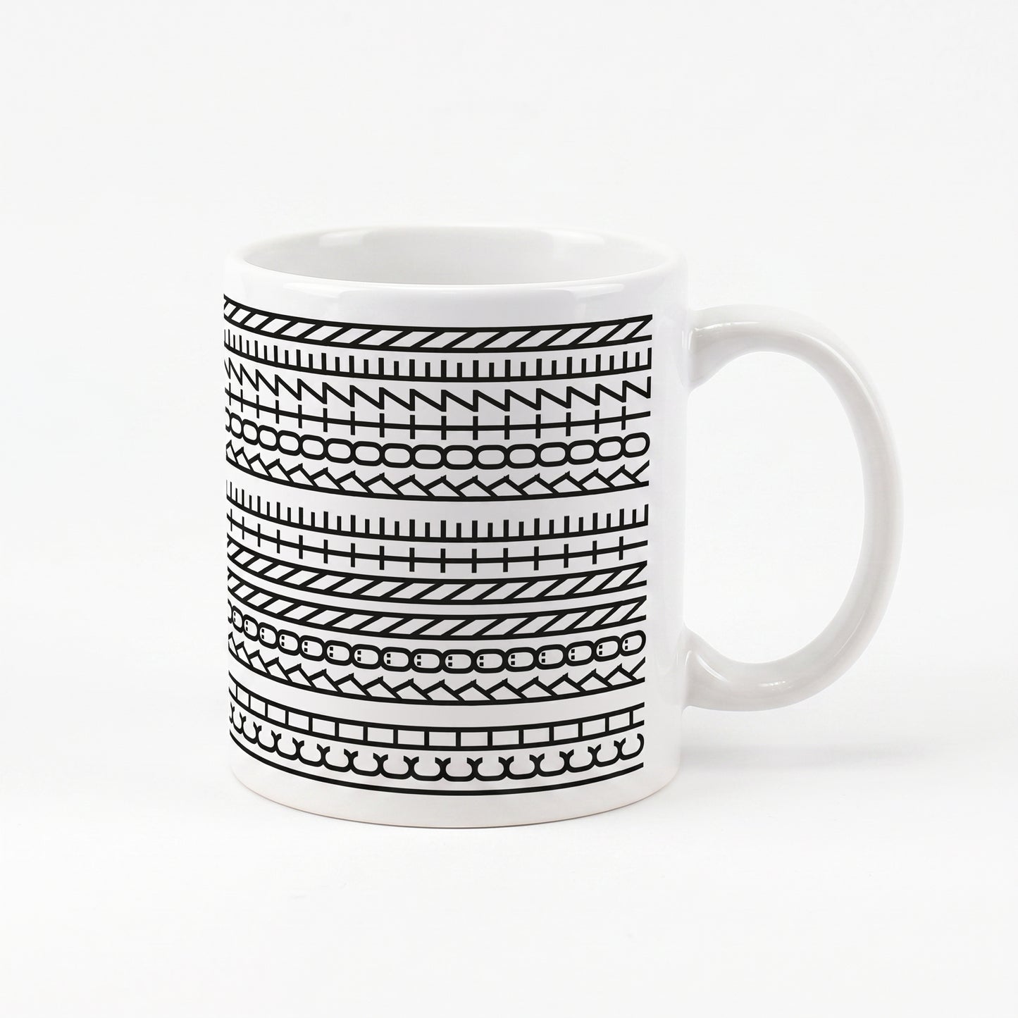 Kaffeetasse mit schwarzem Muster und versteckter Botschaft „Ich könnte kotzen“ auf weißem Hintergrund