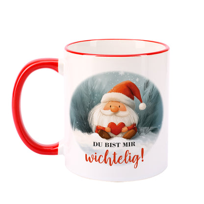 Keramiktasse mit Wichtel in roter Mütze und Herz, Aufdruck „Du bist mir wichtelig!“, freigestellt – Vorderseite mit rotem Henkel.