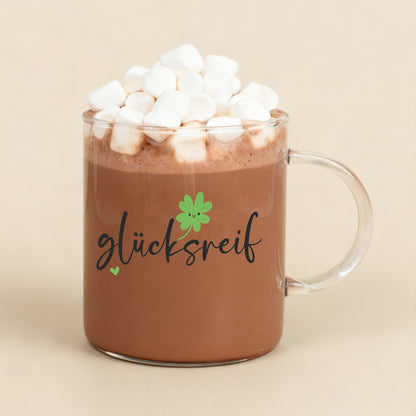 Teeglas mit „glücksreif“-Motiv gefüllt mit Kakao und Marshmallows