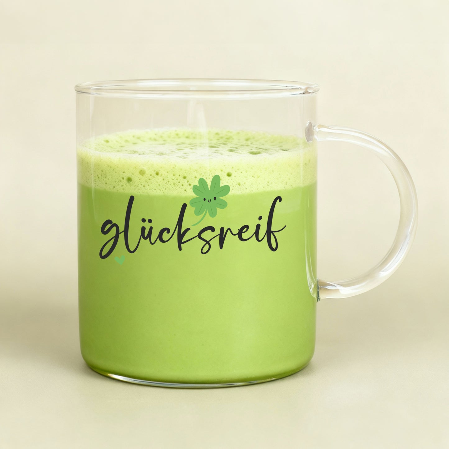 Großes Teeglas mit grünem Matcha-Getränk und „glücksreif“-Aufdruck