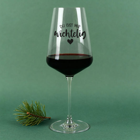 Weihnachts-Weinglas von Leonardo mit Spruch „Du bist mir wichtelig“ und Herz, auf grünem Hintergrund mit Tannenzweig