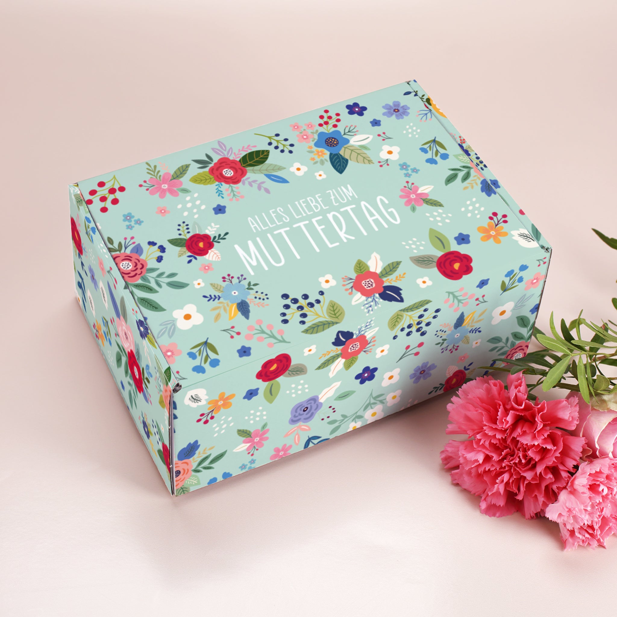 Geschenkverpackung zum Muttertag im floralen Look, rechteckig mit Aufdruck Alles Liebe zum Muttertag und rosa Nelken als Dekoration