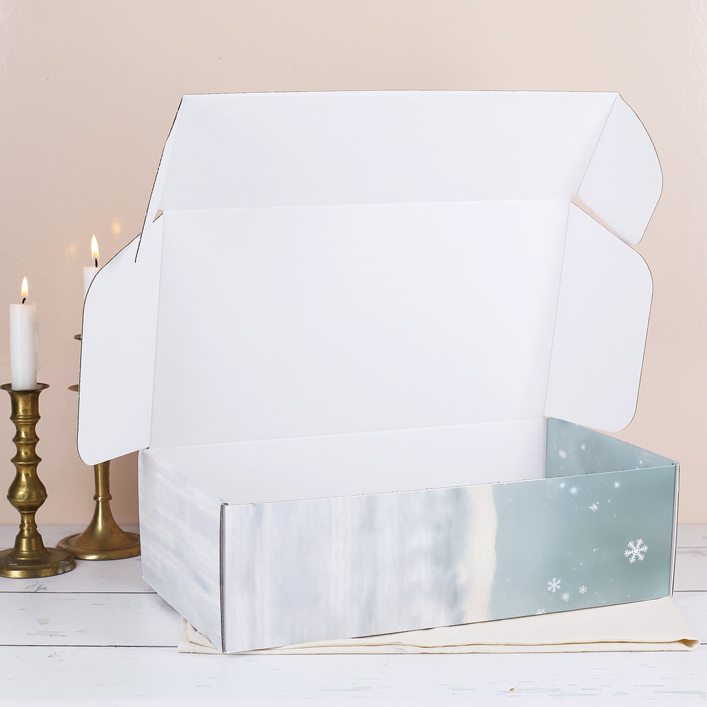 Geöffnete Geschenkbox mit winterlichem Druck, leer und von innen weiß