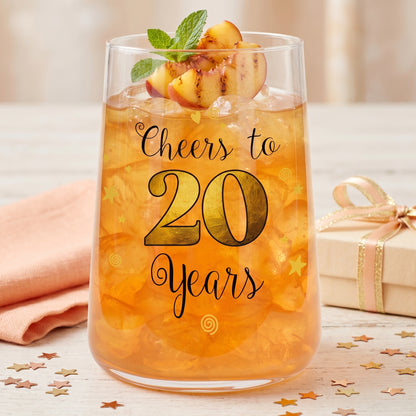 Partyglas zum 20. Geburtstag mit orangefarbenem Getränk, Sternkonfetti und festlichem Geburtstagsdesign