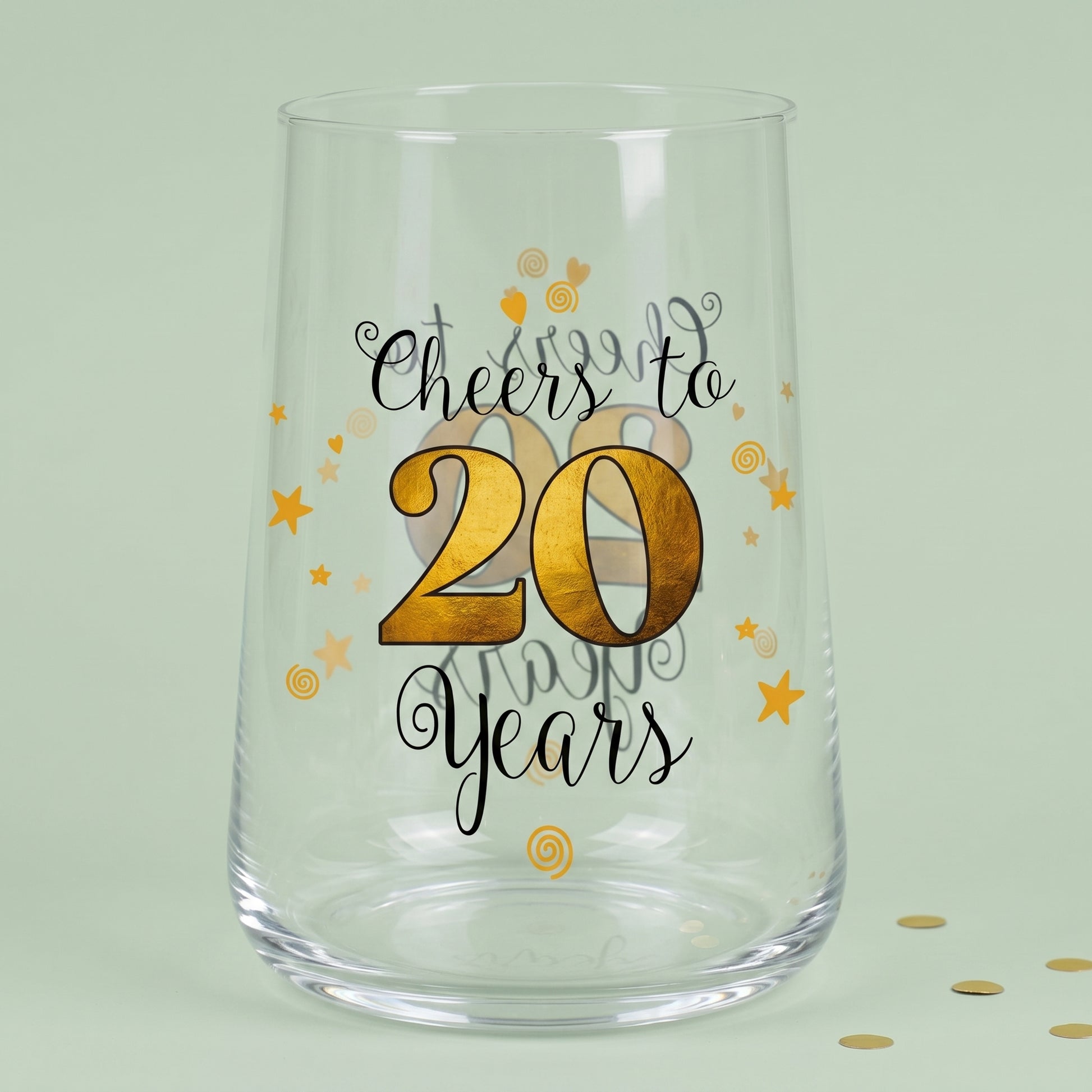 Leeres Trinkglas zum 20. Geburtstag mit Cheers to 20 Years Aufdruck und goldener 20 auf grünem Hintergrund