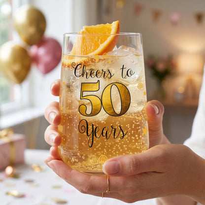 Trinkglas zum 50. Geburtstag wird in den Händen gehalten