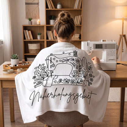 Weiße Kuscheldecke mit Nähmaschine und Schriftzug Näherholungsgebiet beim Nähen